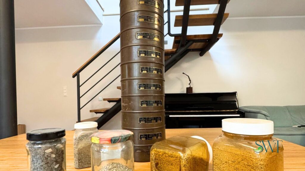Siebturm – historische Siebsäule Historische Siebsäule aus Kupfer mit gestapelten Prüfsieben auf einem Schreibtisch